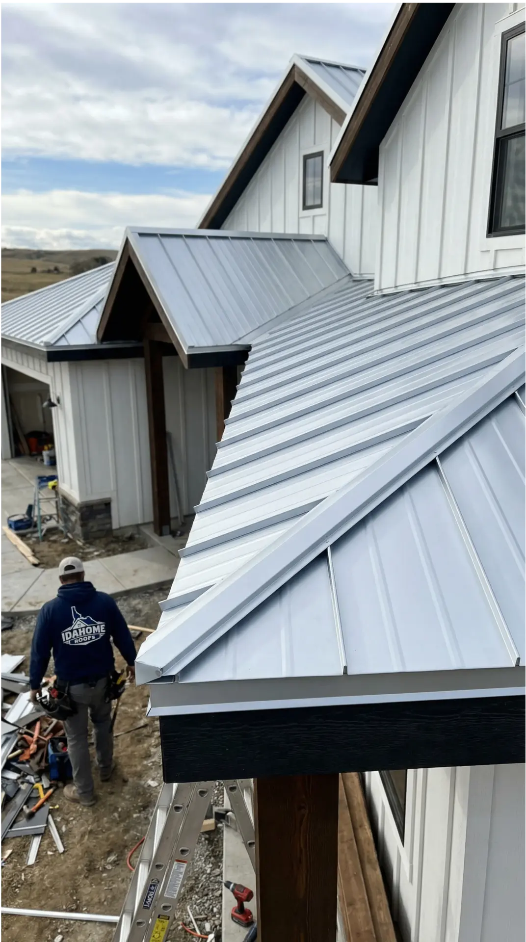 Idahome Roofs crew member installing a standing-seam metal roof